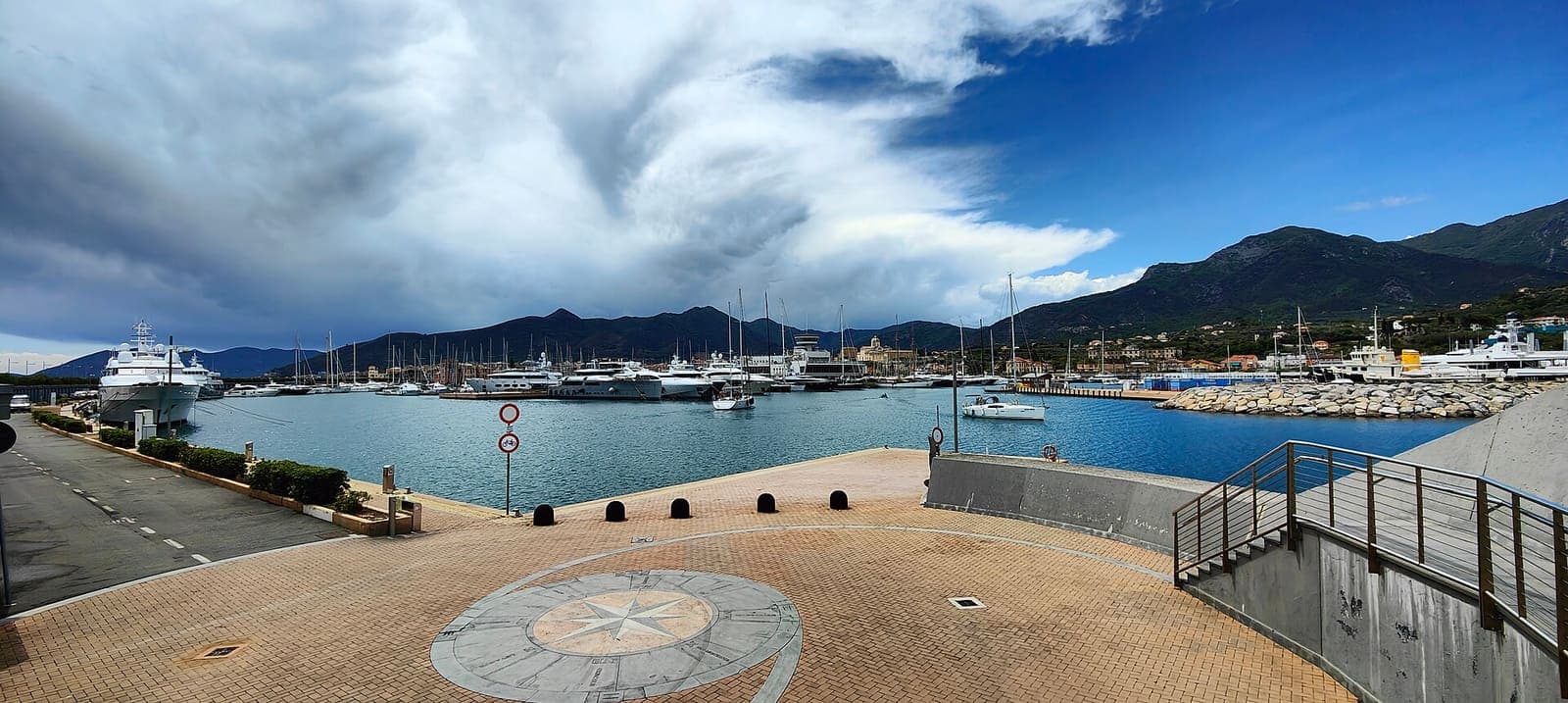 Panorama der Marina di Loano mit Yachten und Bergen im Hintergrund