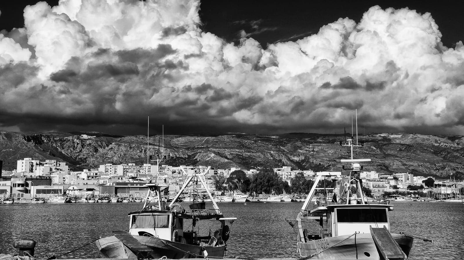 Pescherecci nel porto di Manfredonia con la città e il Gargano sullo sfondo